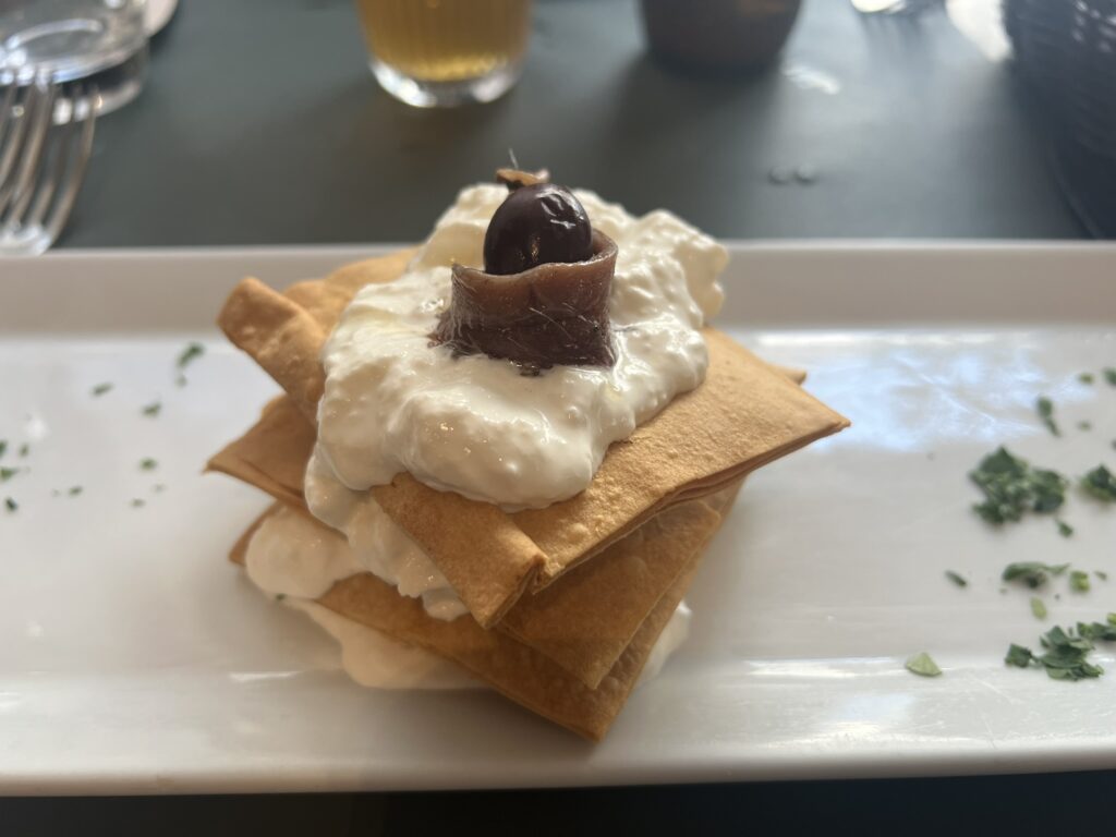 Crispy flatbread layered with whipped cream cheese and olive appetizer at Hosteria Grappolo d'Oro, Rome