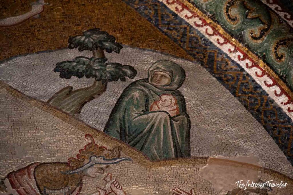 Byzantine mosaic detail at Chora Church Istanbul, hooded figure holding infant amid golden tesserae