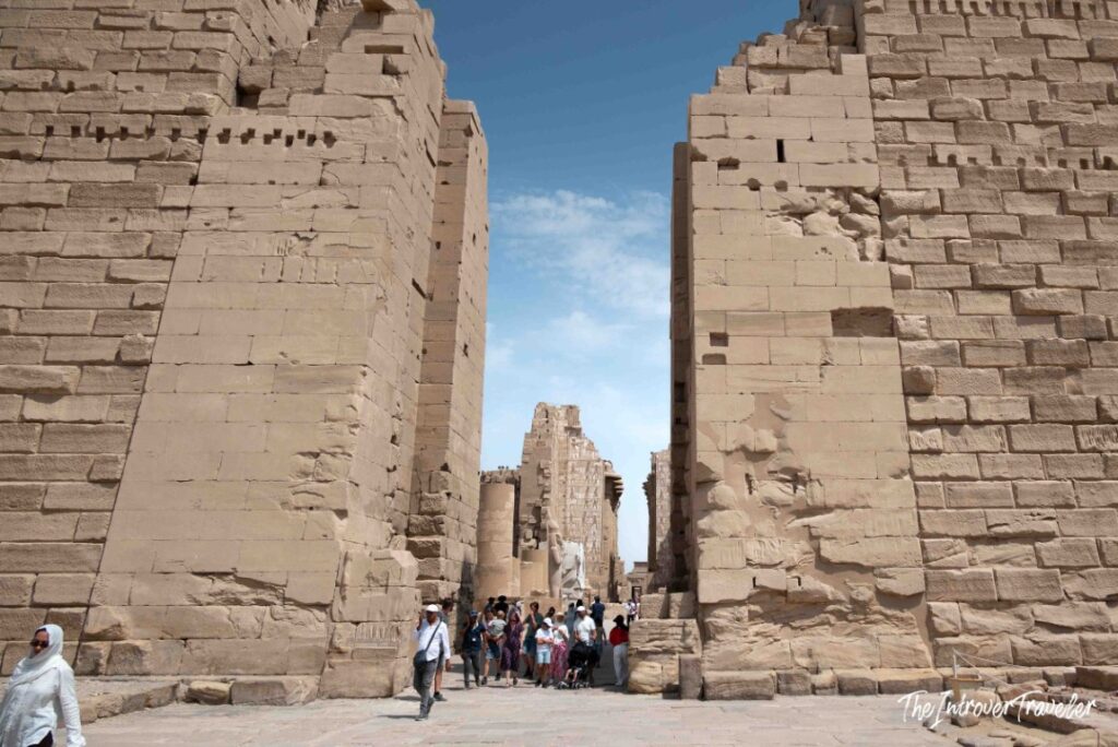 Tourists walking through the massive First Pylon gateway into Karnak Temple Complex, Luxor, Egypt