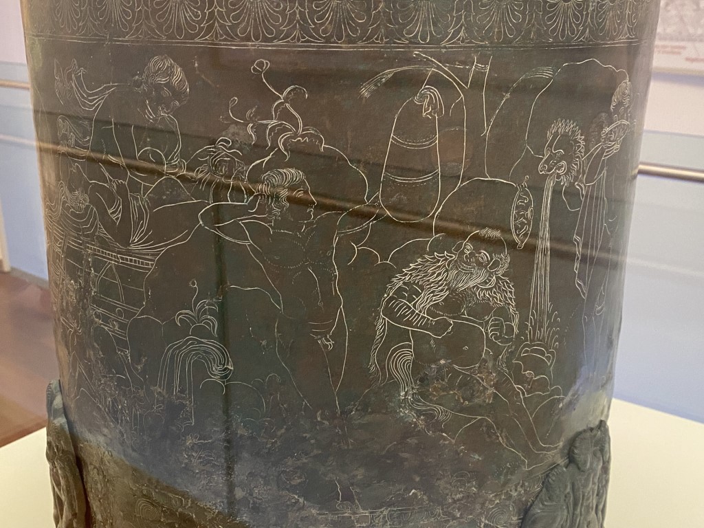 Close-up of engraved mythological figures on an Etruscan bronze cista at Villa Giulia, Rome