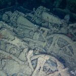 Corroded motorcycles and machinery encrusted in sediment inside the SS Thistlegorm cargo hold, Red Sea