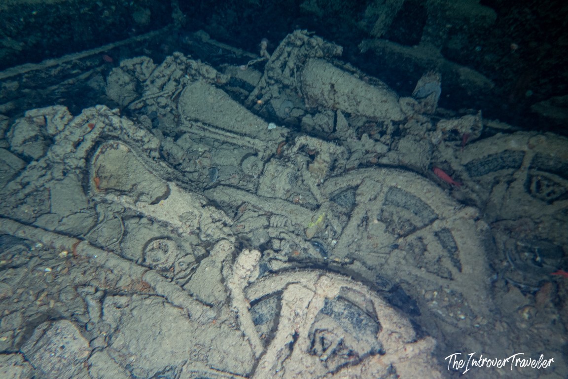 Corroded motorcycles and machinery encrusted in sediment inside the SS Thistlegorm cargo hold, Red Sea