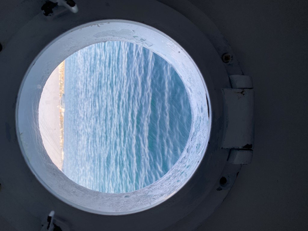 View of the Red Sea through a ship porthole on the first day of a liveaboard dive trip