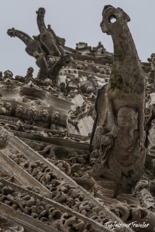 Close-up of a grotesque gargoyle on Rouen Cathedral, showcasing its intricate Gothic stone carvings
