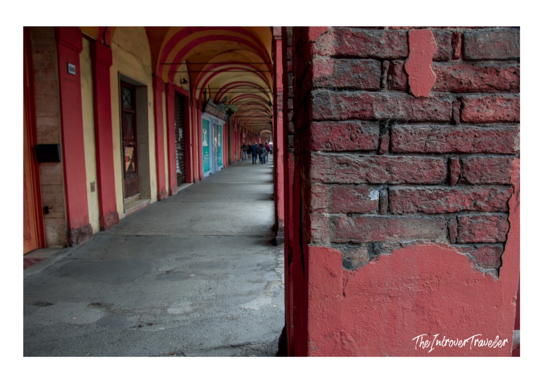 Bologna's iconic red porticoes, a UNESCO World Heritage corridor leading past local shops