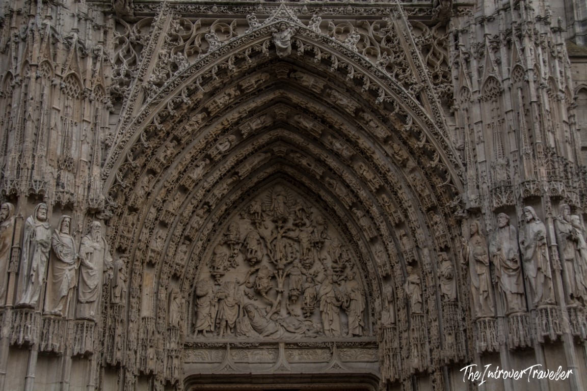 Ornate Gothic portal of Rouen Cathedral, with layered stone arches and detailed religious relief sculptures