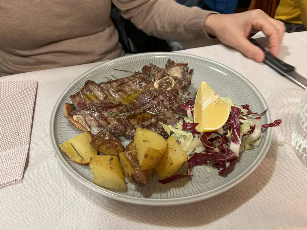 Grilled lamb chops with roasted potatoes and radicchio salad at Trattoria Casa Mia, Bologna