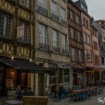 Colorful half-timbered medieval buildings lining a cobblestone street in Rouen, Normandy