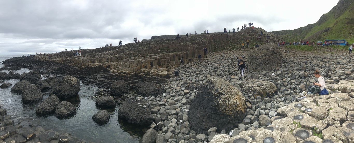 Tourists exploring the Giant's Causeway hexagonal basalt columns on the Northern Ireland coastline