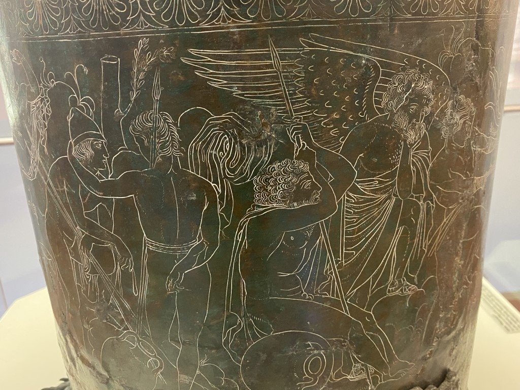 Engraved bronze situla at Villa Giulia, showing winged figures and warriors in Etruscan mythological scene