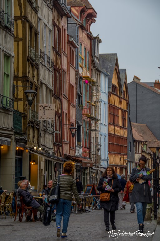 Colorful half-timbered buildings lining a busy pedestrian street in Rouen, Normandy