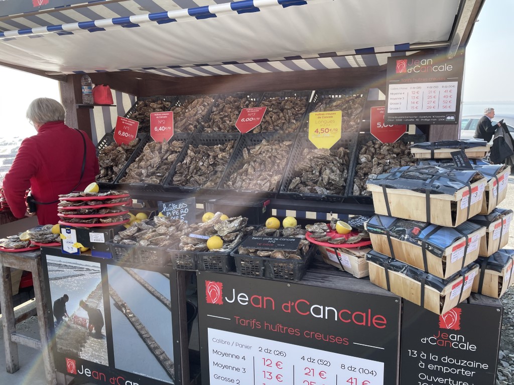 Jean d'Cancale outdoor oyster stall in Cancale, Brittany, selling fresh huîtres creuses with price boards