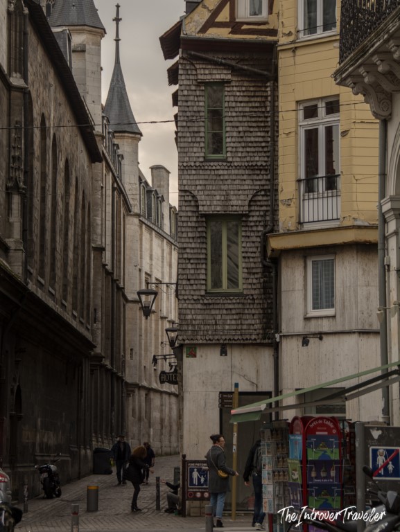 Narrow medieval street in Rouen with a timber-shingled tower and Gothic spire in Normandy, France