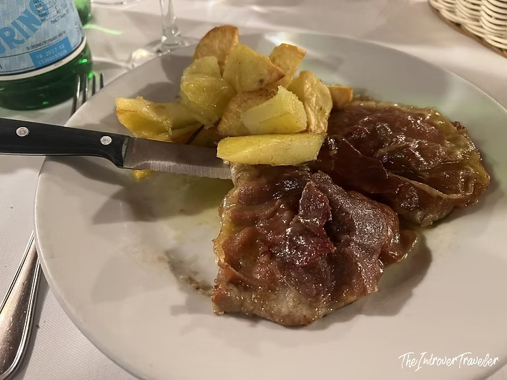 Tough overcooked saltimbocca with roasted potatoes at Checco er Carettiere, Rome