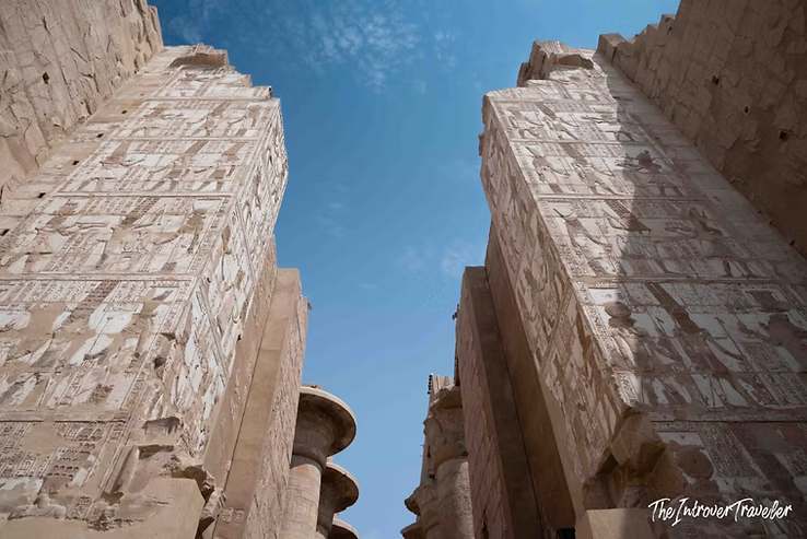 Upward view of hieroglyph-covered pylons at Karnak Temple's Hypostyle Hall, Luxor