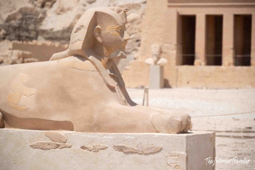 Sphinx statue at the Temple of Hatshepsut, Deir el-Bahari, with carved hieroglyphs on its base
