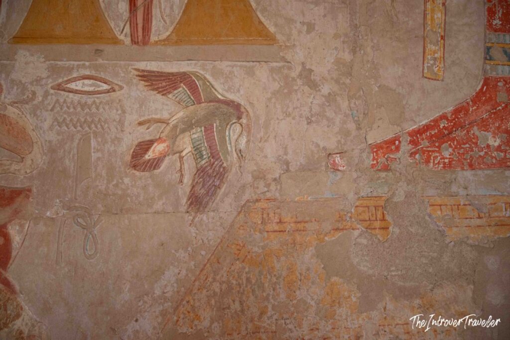 Colorful ancient Egyptian wall painting of a flying bird with hieroglyphs, Temple of Hatshepsut, Luxor