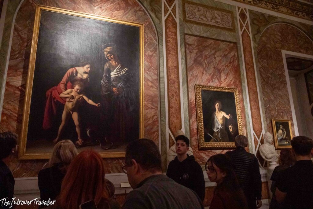 Visitors in front of Caravaggio's Madonna dei Palafrenieri in the Room of the Silenus, Borghese Gallery, Rome