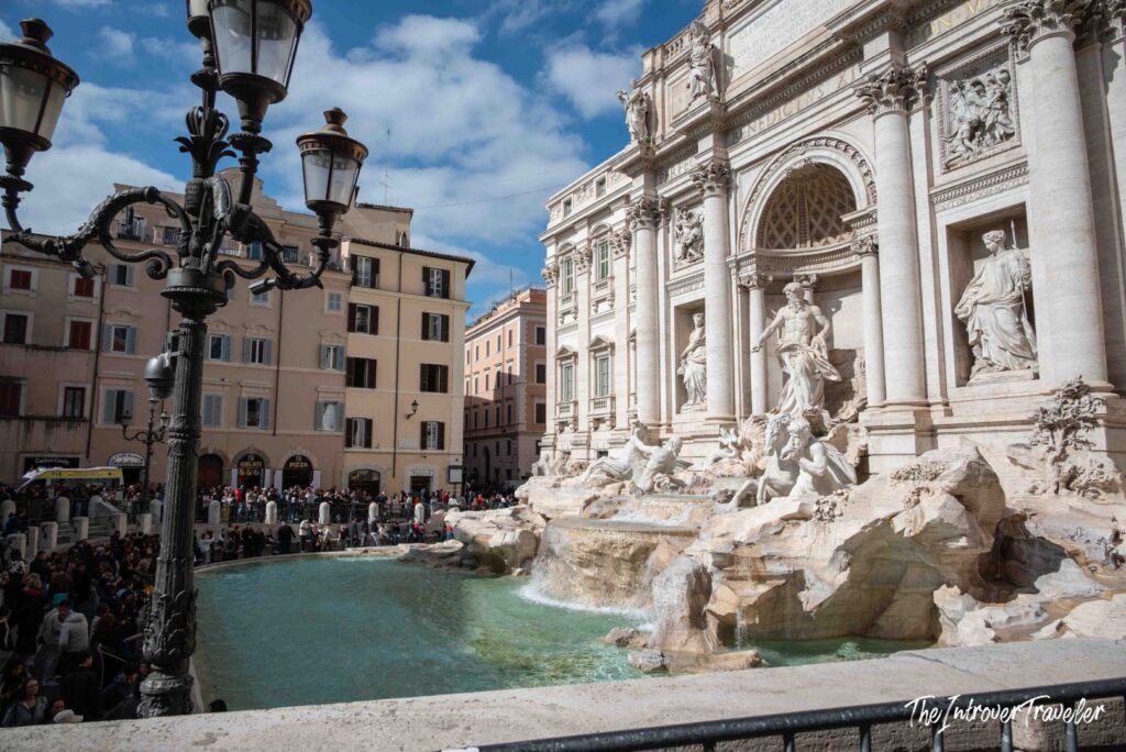 Trevi Fountain framed by a street lamp, with the square and the basin, Rome