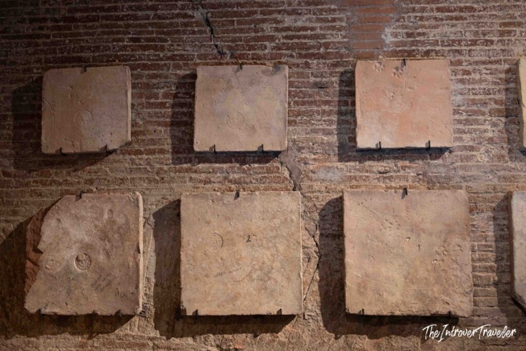 Roman bricks with stamps displayed on a brick wall in the Oltre il Pantheon route, Pantheon, Rome
